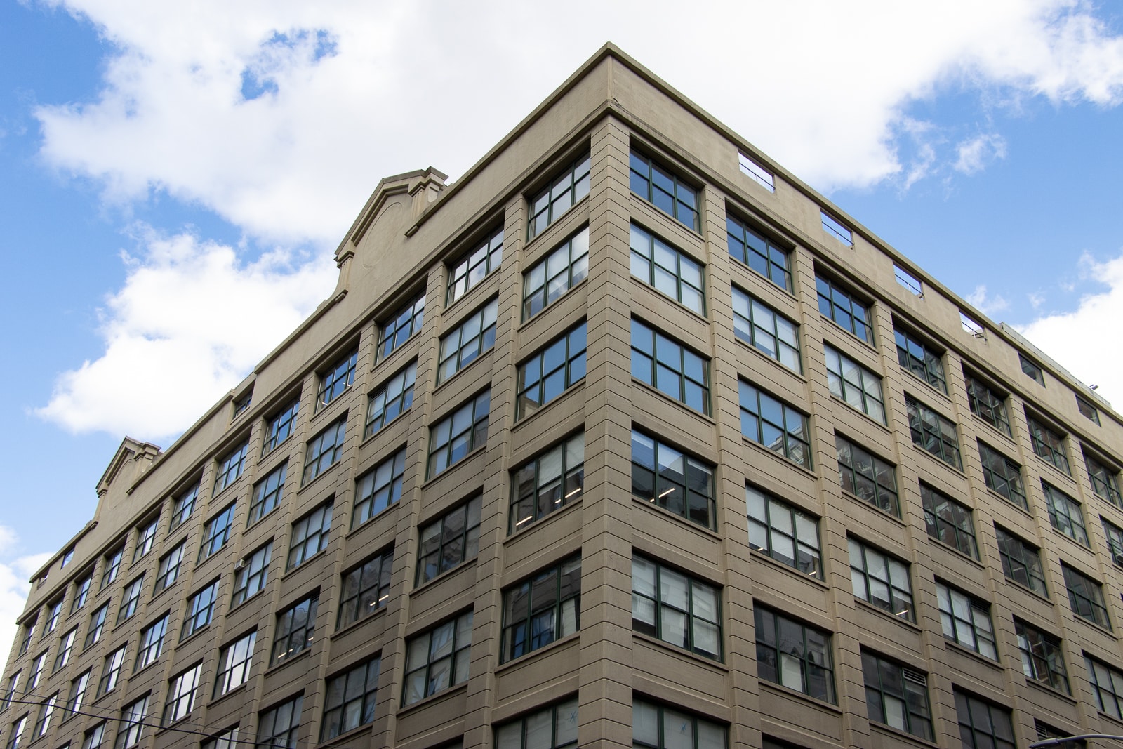 upper stories of a reinforced concrete building with a blue sky and clouds