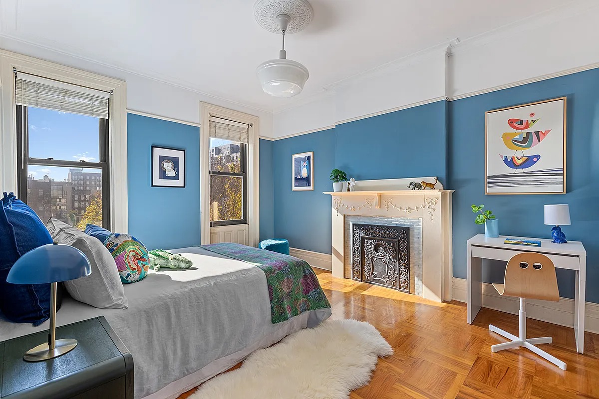 bedroom with white mantel, blue walls