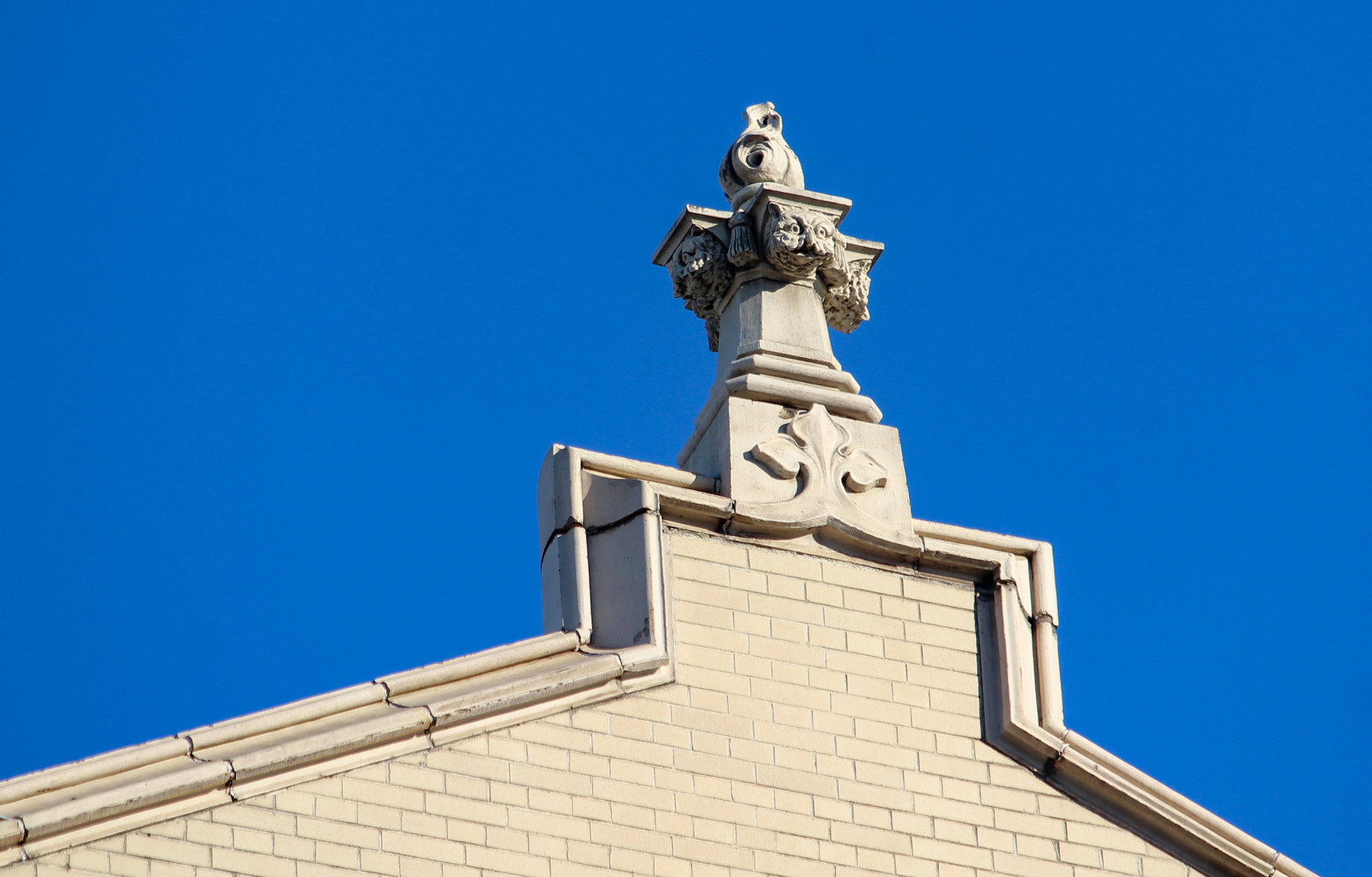 decorative detail at the top of the building includes faces