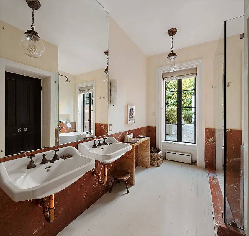 bathroom with two, wall mounted sinks and a walk-in shower