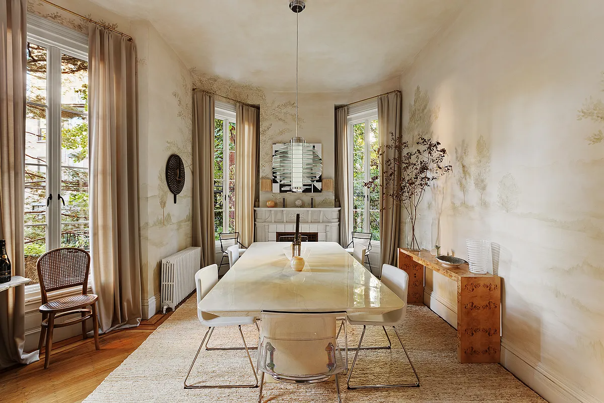 dining room with a mantel and with a scenic landscape of trees painted on the walls