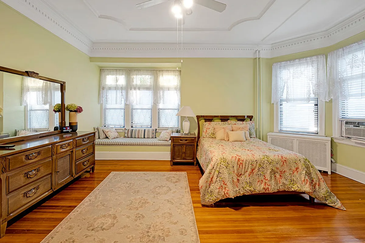 bedroom with window seat, wood floor