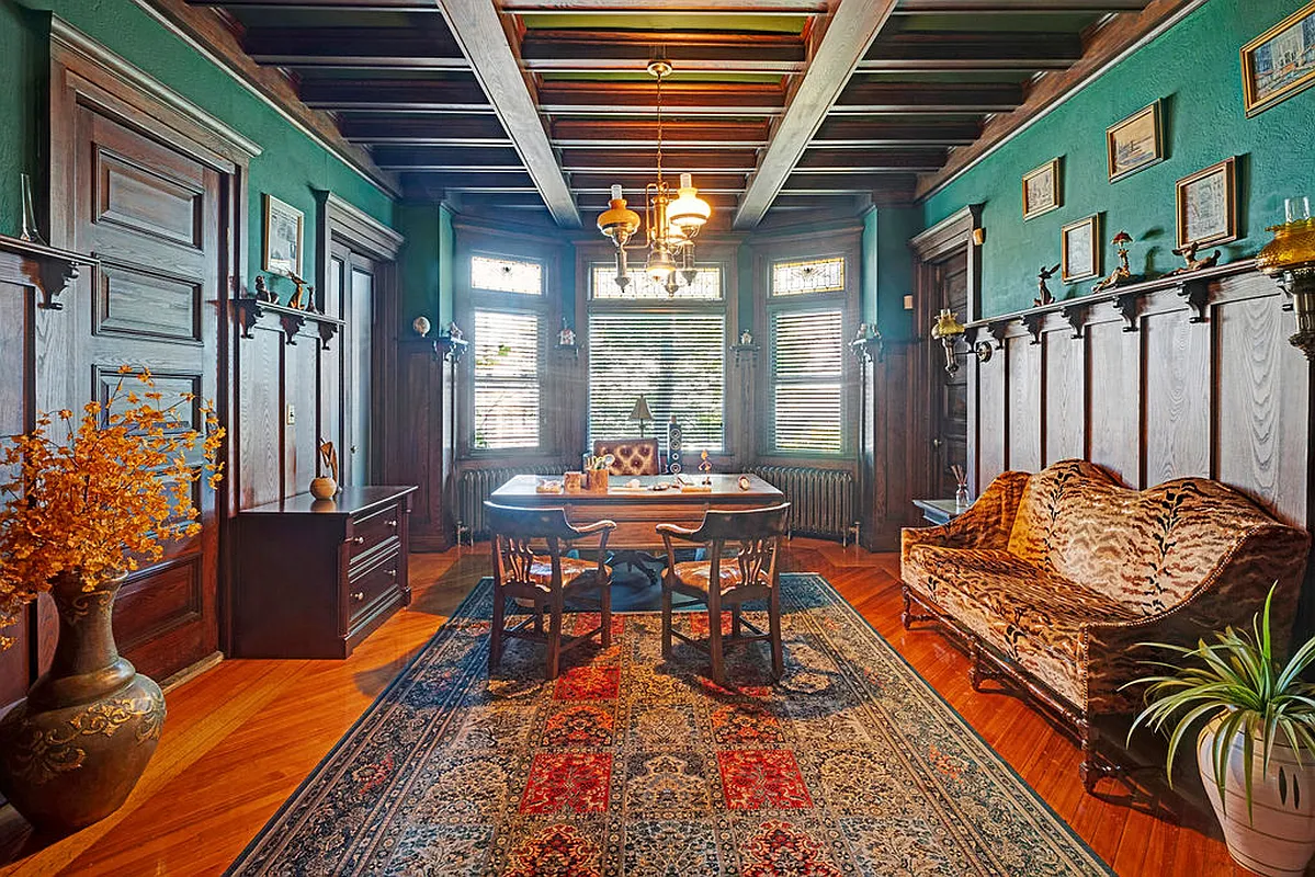 original dining room with wainscoting, plate shelf, beamed ceiling, stained glass