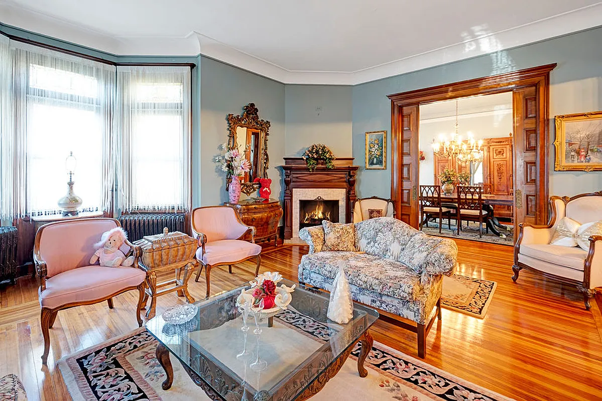 parlor with pocket doors, crown molding, wood floor