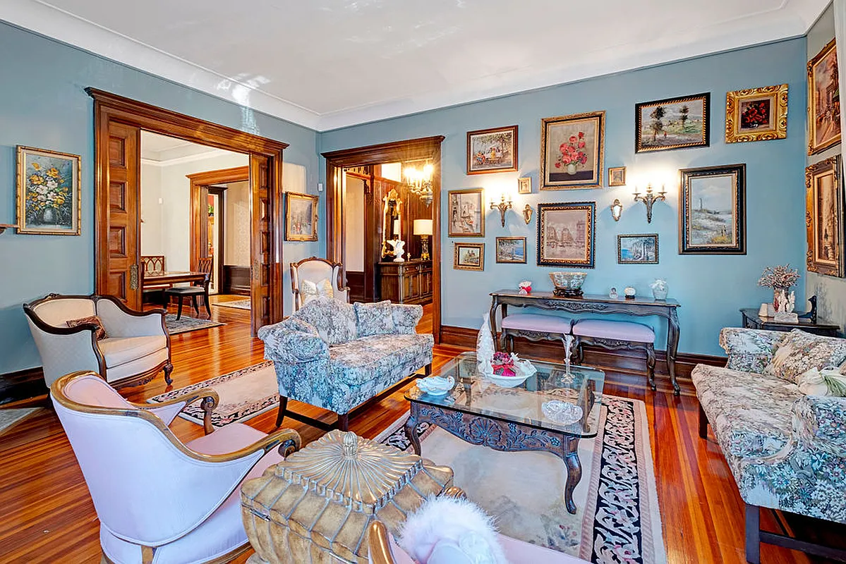 parlor with pocket doors, crown molding, wood floor, blue walls