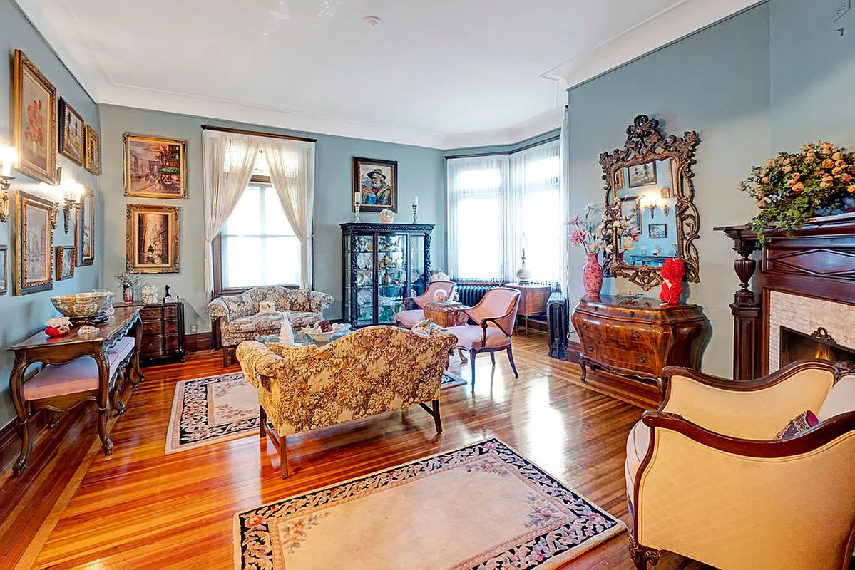 parlor with mantel, crown molding, wood floor