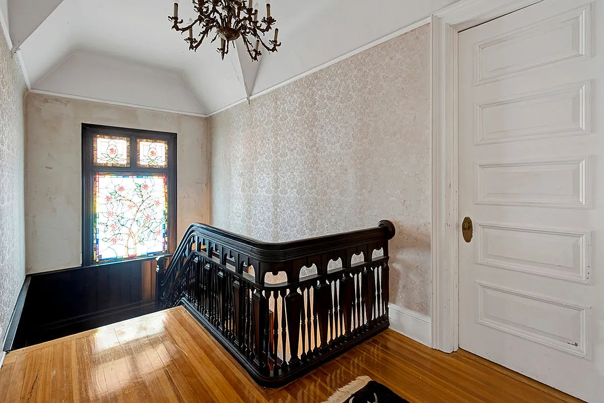 upstairs hall with stained glass window at stair landing