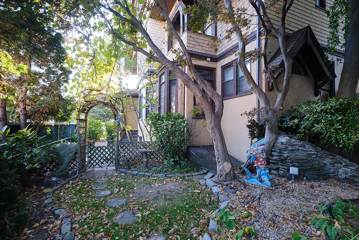 yard with planting beds and a gate with an arbor