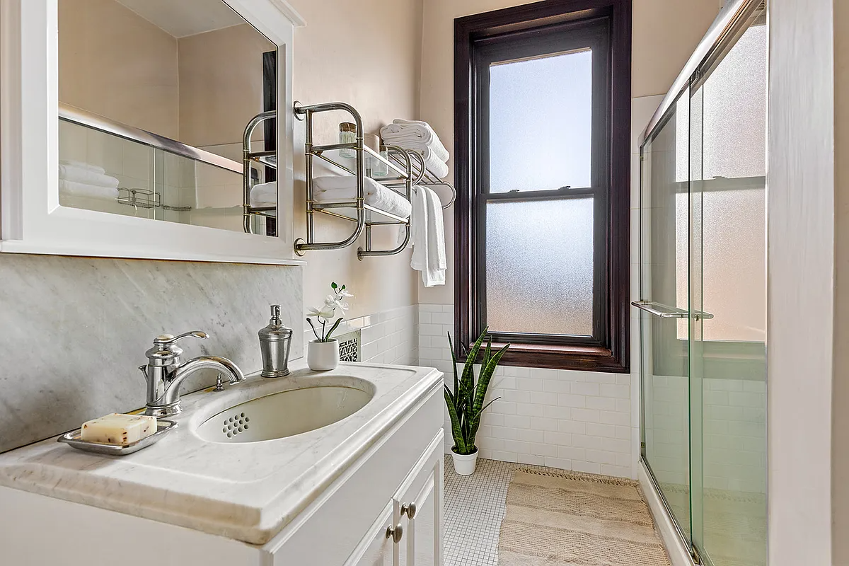 bath with marble sink, glass doors on shower