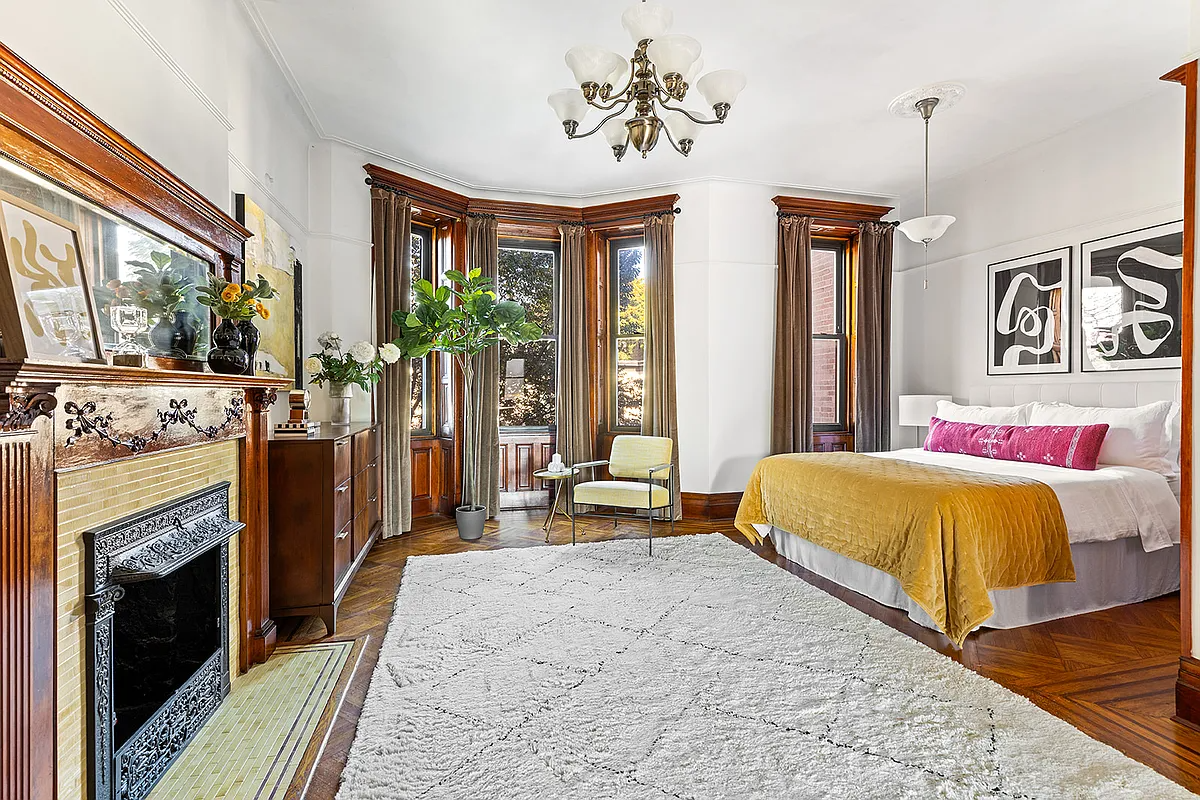 bedroom with wood mantel, bay window