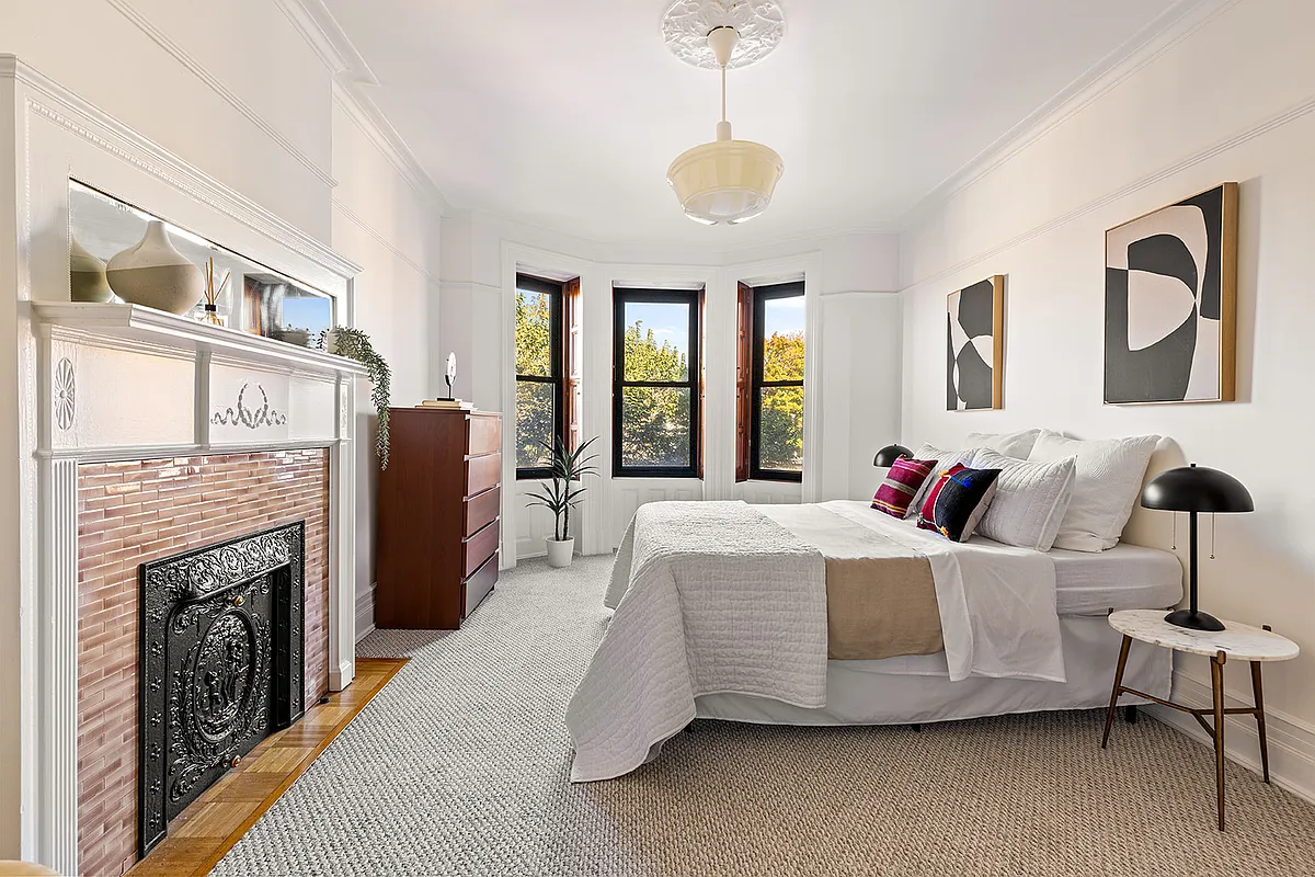 bedroom with white mantel and a ceiling medallion