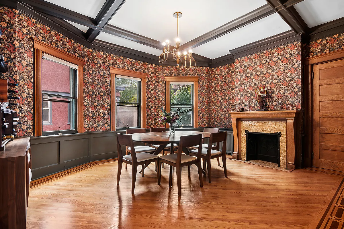 dining room with mantel, wood floor, floral wallpaper