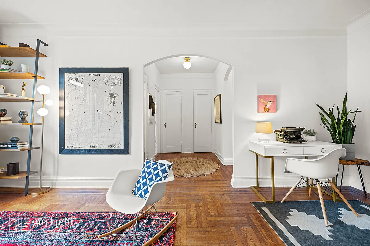 living room with wood floor, arched doorway, white walls