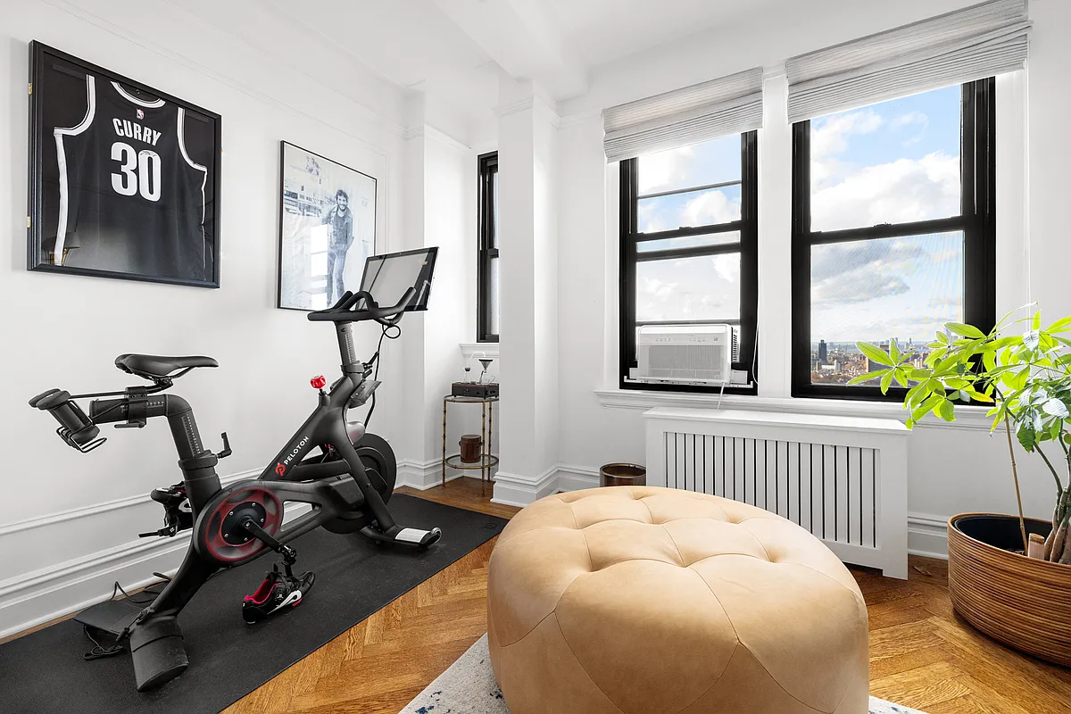 bedroom with wall moldings, wood floors, and three windows set up as an office