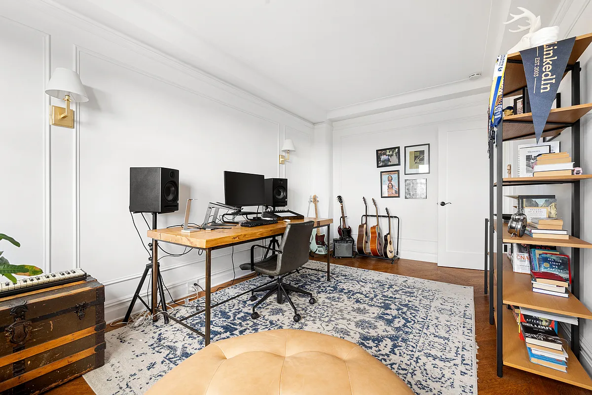 bedroom with wall moldings, wood floors, set up as an office