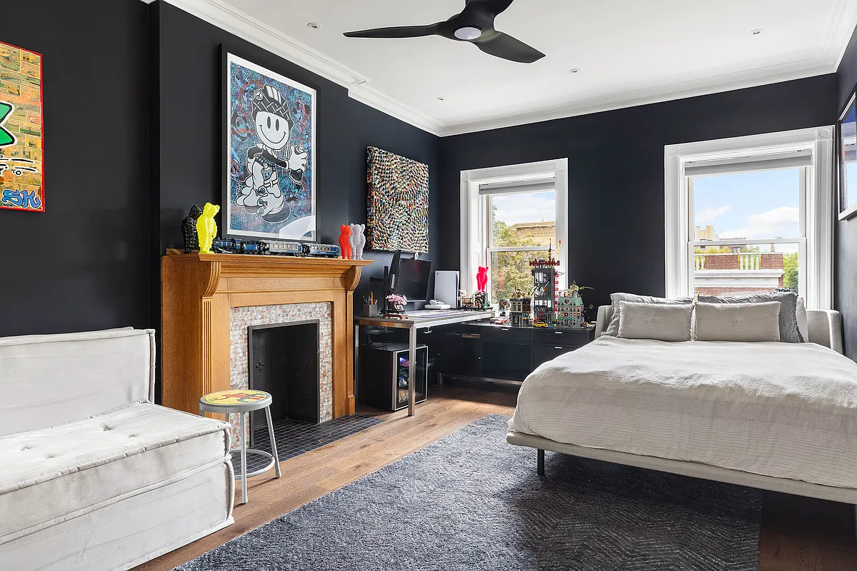 a bedroom with dark blue walls and a mantel