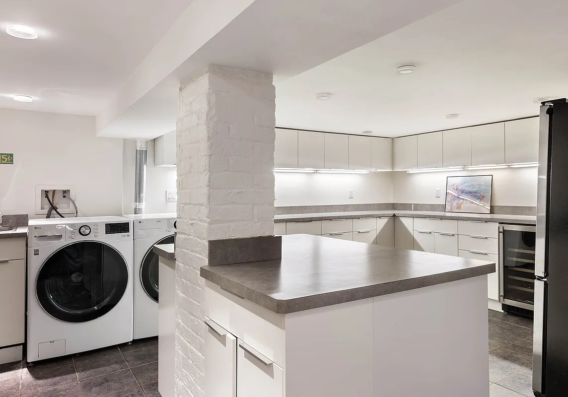 laundry room with upper and lower cupboards and an island