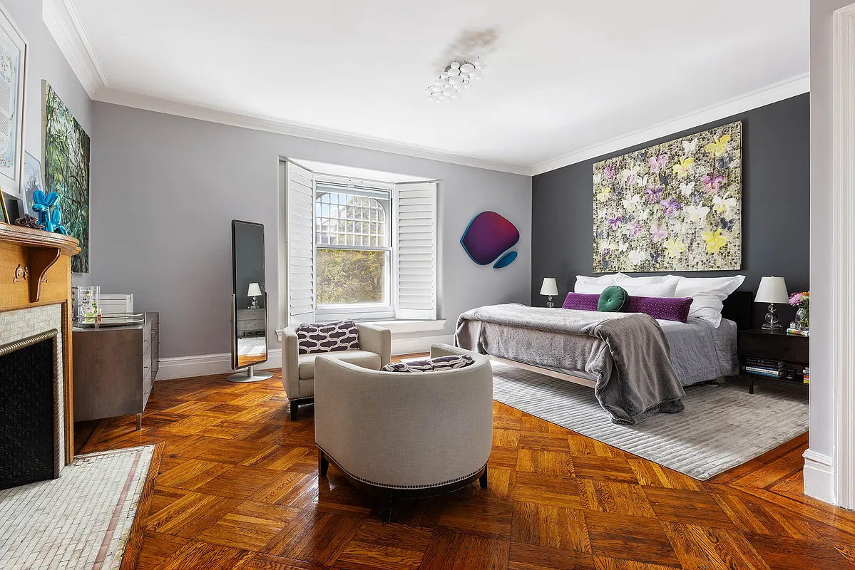 a bedroom with wood floor and a wood mantel with cream tile surround