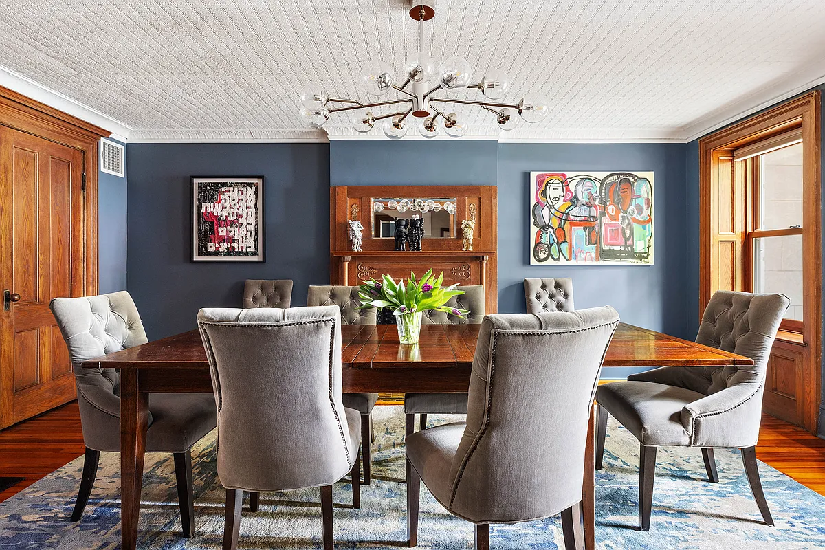 the garden level dining room with a tin ceiling and a mantel