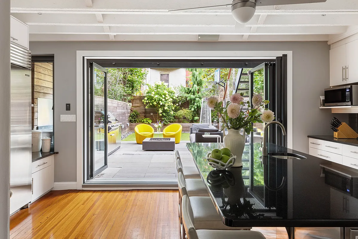 wall of glass in kitchen opens to the rear yard