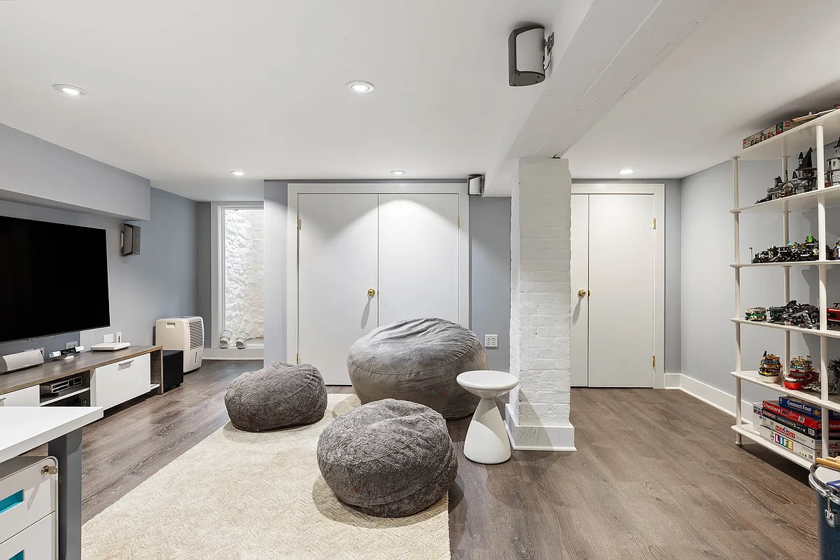 media room with a faux wood floor and storage space