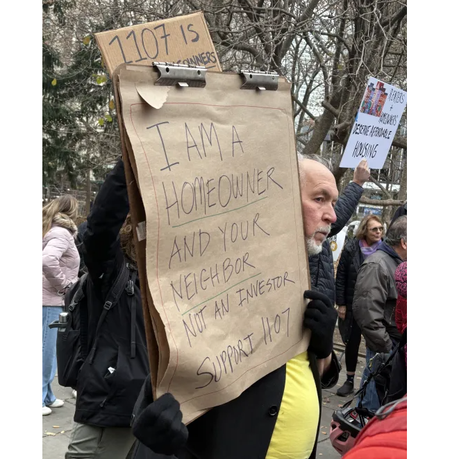 homeowners holding signs at the rally